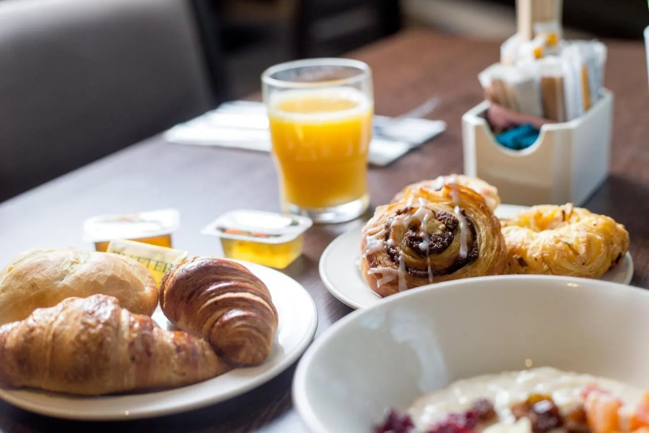 a table with plates of pastries and a glass of orange juice at President Hotel in London