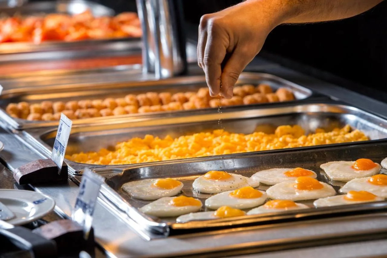 a person is reaching for a tray of food at President Hotel in London